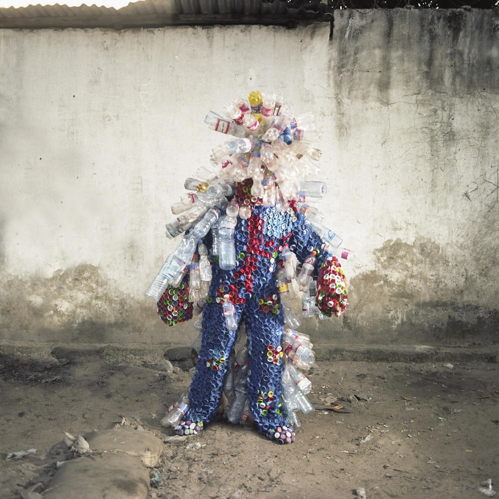Junior Mungongu shows off the costume he created out of plastic bottles and lids.