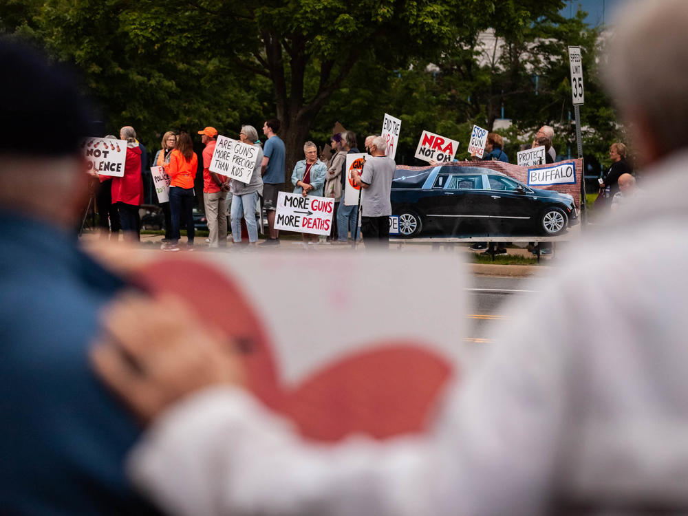 Demonstrators attend a candlelight vigil Wednesday in Fairfax, Va., for the victims of the Uvalde and Buffalo mass shootings.