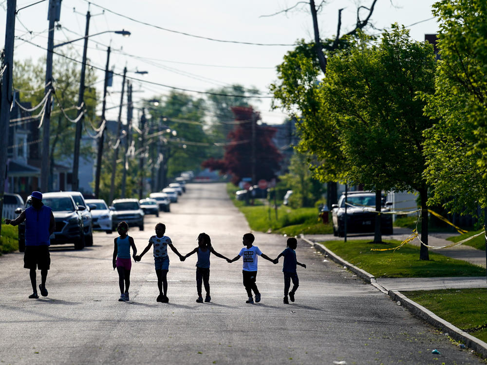 Children walk hand in hand in a street near the scene of a shooting at a supermarket in Buffalo, N.Y. on May 15.