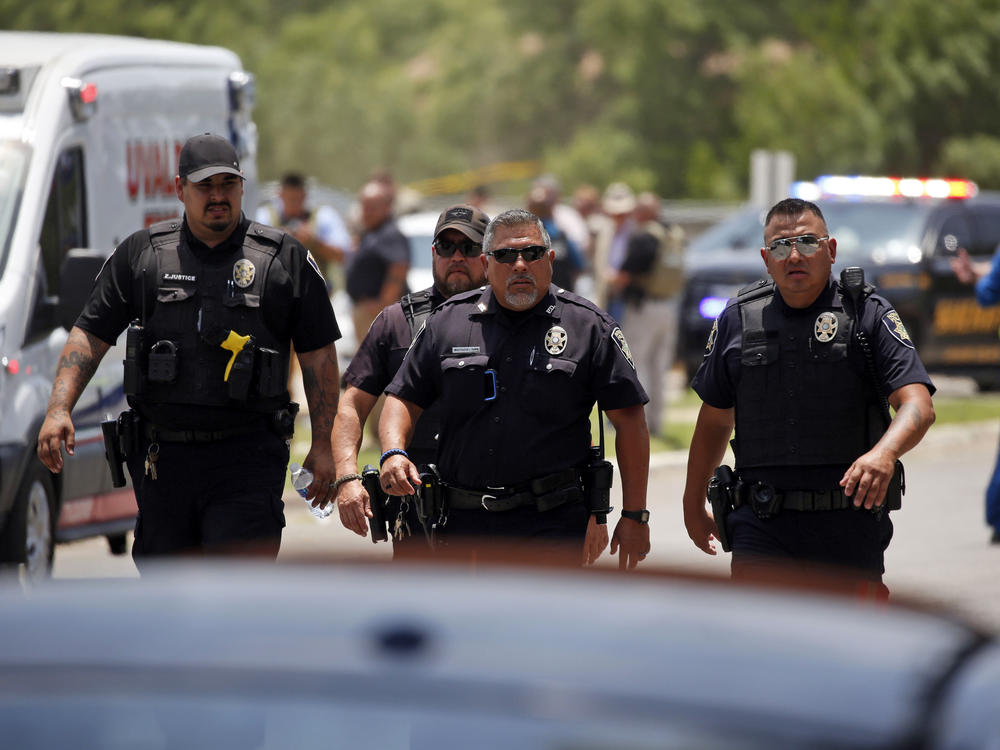 Police walk near Robb Elementary School following the shooting on Tuesday.