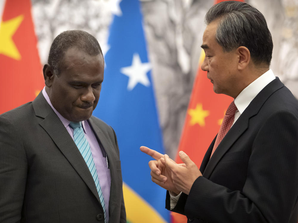 Solomon Islands Foreign Minister Jeremiah Manele, left, and Chinese Foreign Minister Wang Yi talk during a ceremony to mark the establishment of diplomatic relations between the Solomon Islands and China at the Diaoyutai State Guesthouse in Beijing on Sept. 21, 2019.