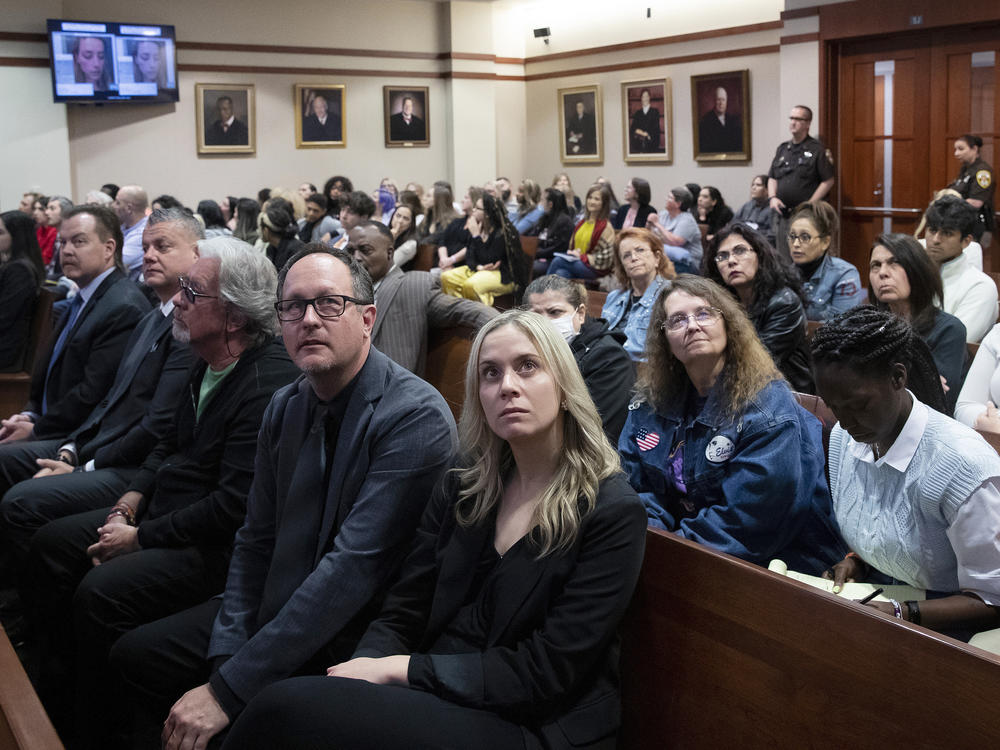 Spectators in court look at monitors in the courtroom at Fairfax County Circuit Court in Fairfax, Va., on Thursday.