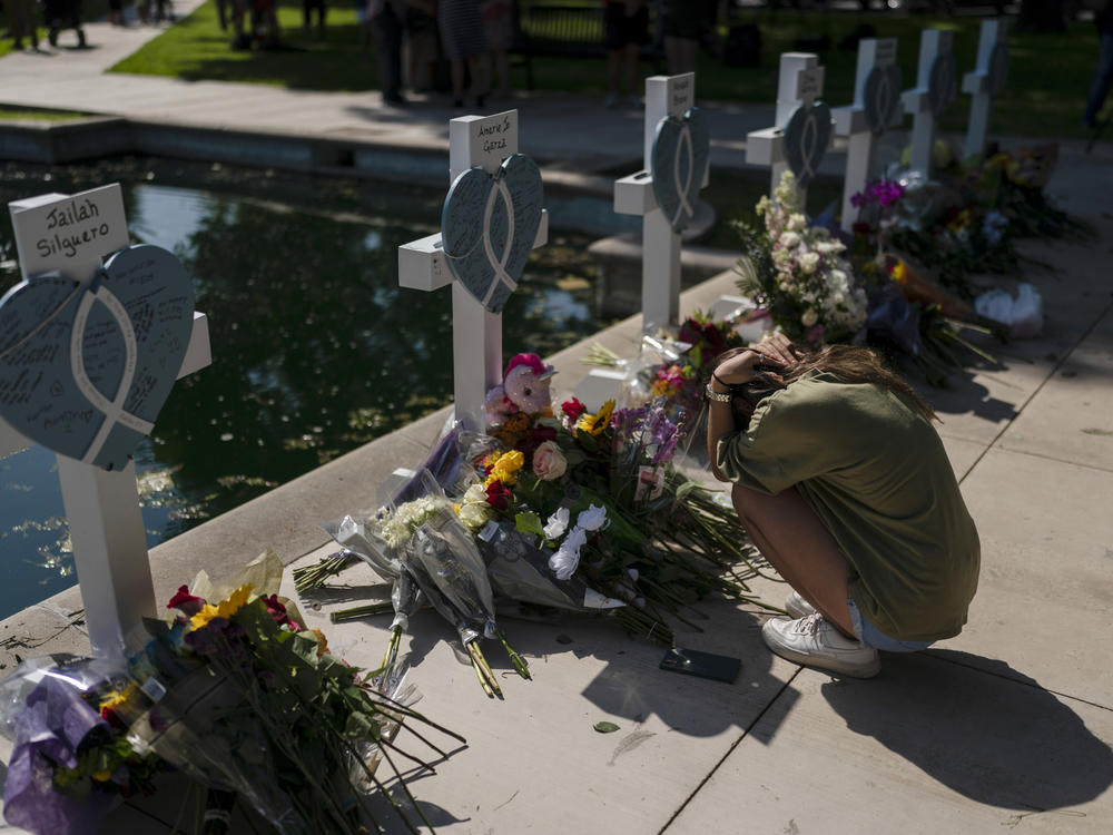 Elena Mendoza, 18, on Thursday grieves in front of a cross honoring her cousin, Amerie Jo Garza, one of the victims killed in this week's elementary school shooting in Uvalde, Texas.