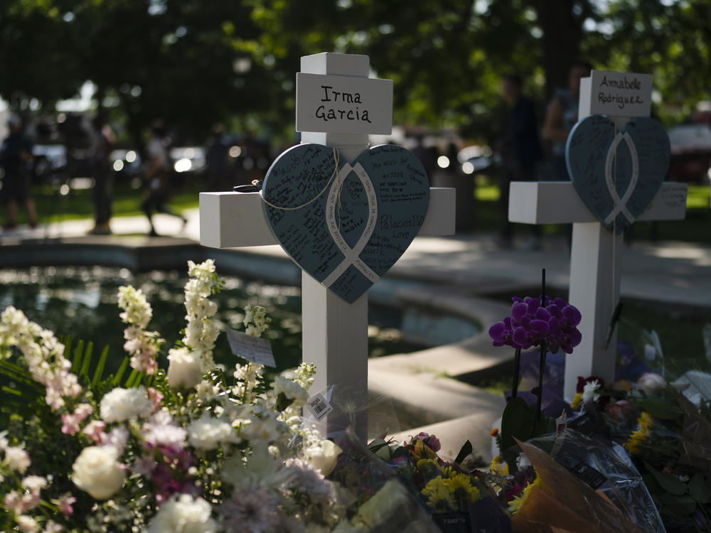 Messages are written on a cross Thursday honoring Irma Garcia, a teacher who was killed in this week's elementary school shooting, in Uvalde, Texas.