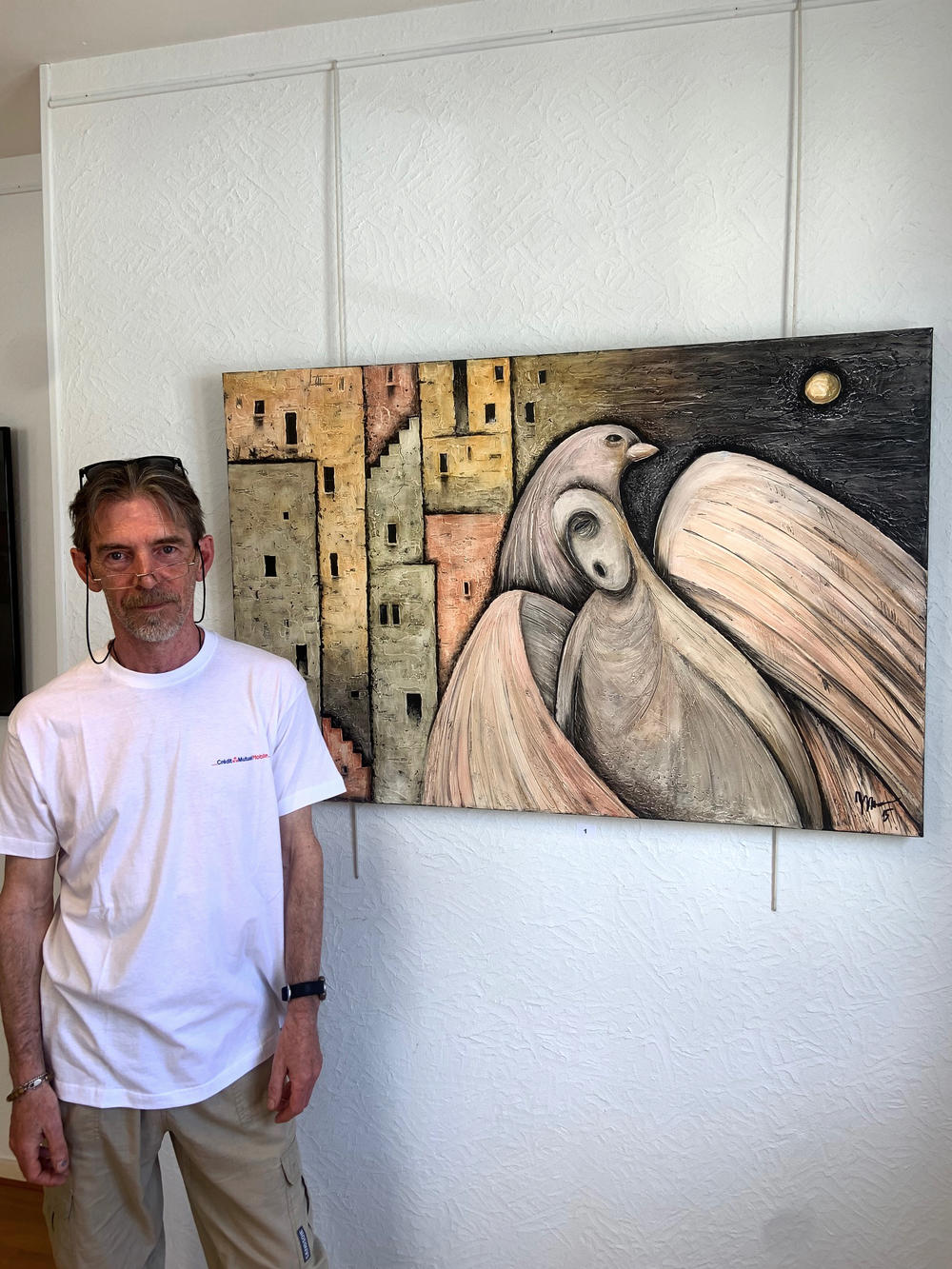 Yuri Mazurenko fled with his wife and their dog and cat from the Ukrainian city of Chernihiv to France. Now he is able to exhibit his art, including this painting called <em>Guard</em>, at the local tourism office in a village in Burgundy.