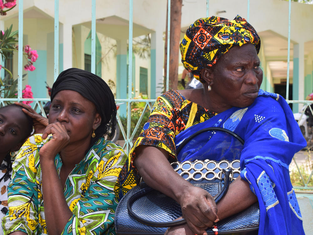 Relatives sit outside the Abdoul Aziz Sy Dabakh Hospital in Tivaouane, Senegal, a town 75 miles northeast of Dakar Thursday, May 26, 2022.