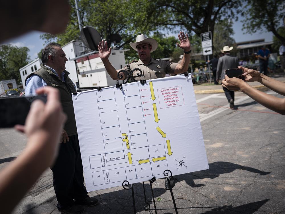 Members of the media take photos of a map of the school which was used at a press conference held outside Robb Elementary School on Friday in Uvalde, Texas.