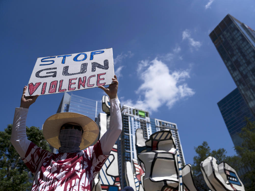 Gun control advocates hold signs during a protest at Discovery Green across from the National Rifle Association Annual Meeting at the George R. Brown Convention Center on Friday in Houston, Texas.