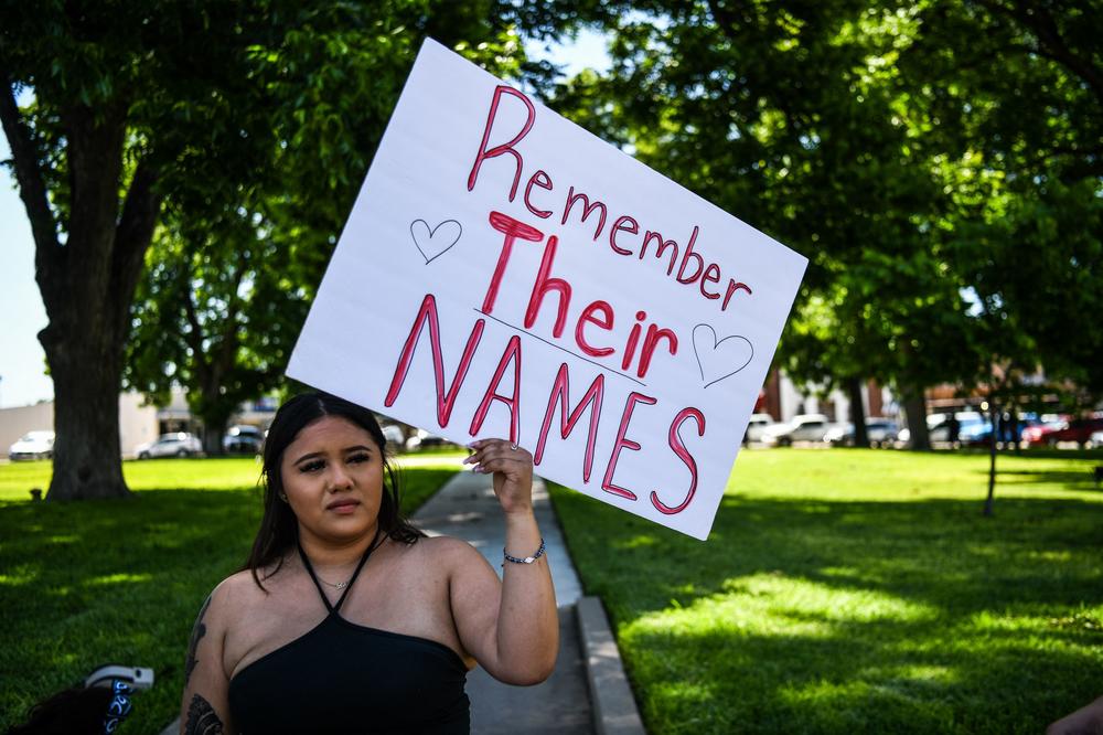 A local resident holds a sign Wednesday honoring the victims of the mass shooting at Robb Elementary School in Uvalde.