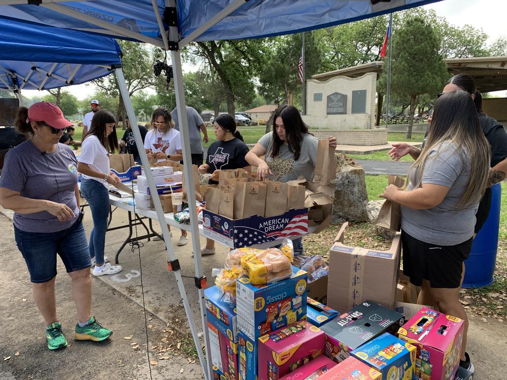 Romie Perez (left) and other volunteers gather at an impromptu cookout to make meals for the families of the victims.