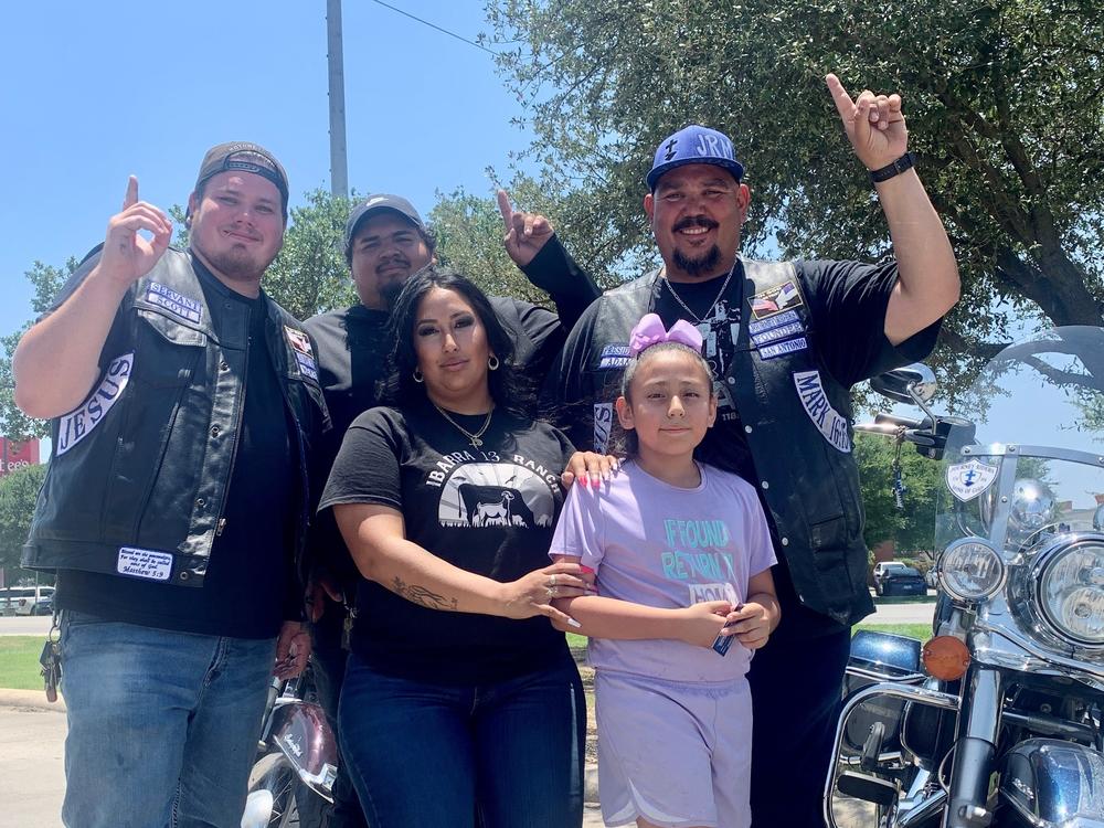 Celeste Ibarra and her daughter, Aubriella Melchor, who survived the mass shooting on Tuesday, prayed with members of the Journey Riders, Sons of God Motorcycle Club, including Adam Torres (far left) at Murphy USA gas station in Uvalde, Texas.