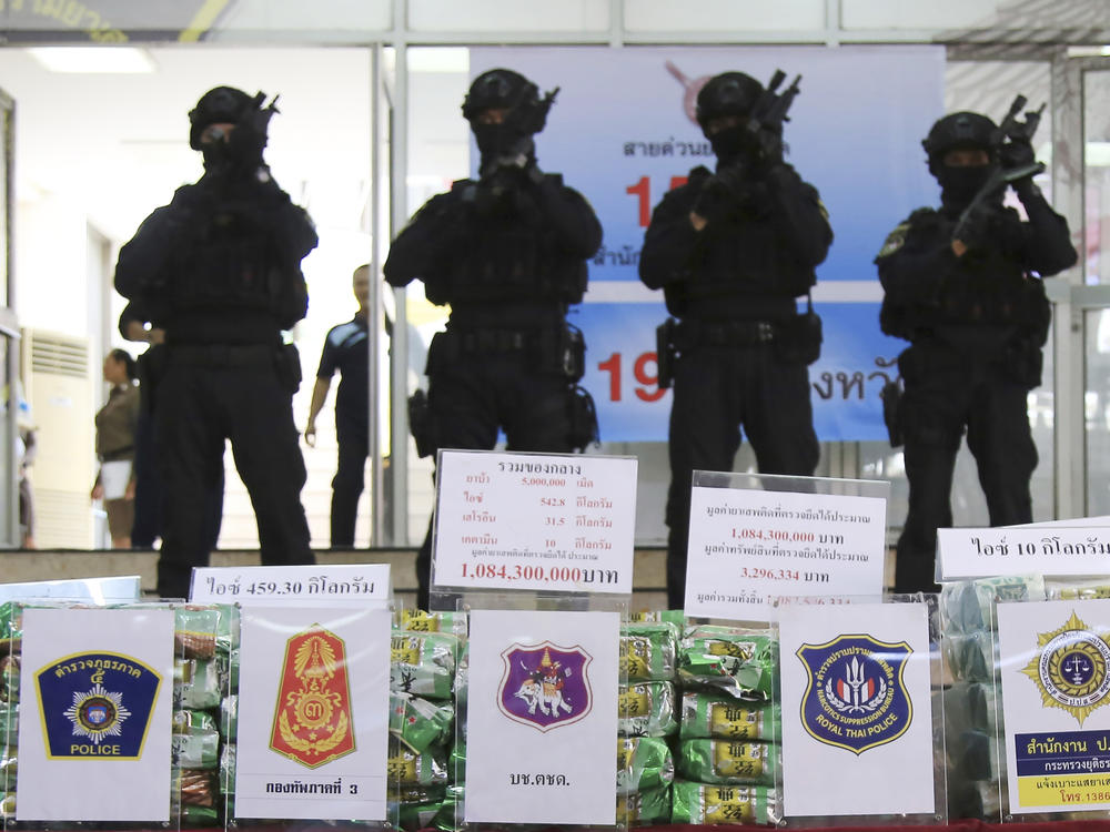 Thai policemen stand in front of packages of methamphetamines on display during a press conference at Narcotics Suppression Bureau in Bangkok, Thailand on July 15, 2019.