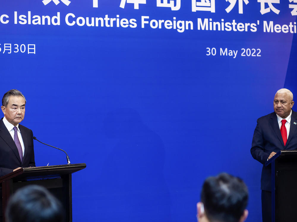 China's Foreign Minister Wang Yi, left, appears on stage at the Pacific Islands Foreign Ministers' meeting with Fiji's Prime Minister Frank Bainimarama, Monday, May 30, 2022, in Suva, Fiji.