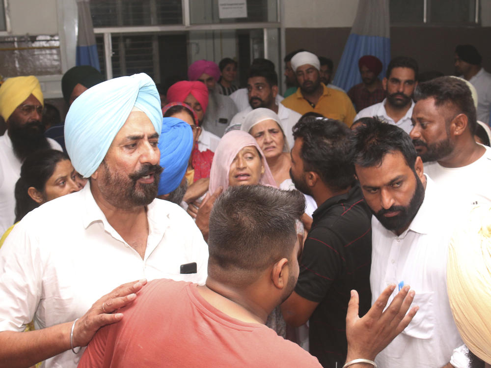 Relatives and friends of Shubhdeep Singh Sidhu, also known around the world by his stage name Sidhu Moose Wala, arrive at a hospital after he was shot in Mansa, India on Sunday.