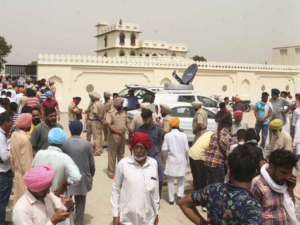 Villagers gather outside the residence of Shubhdeep Singh Sidhu, also known around the world by his stage name Sidhu Moose Wala, in a village near in Mansa, India on Monday.