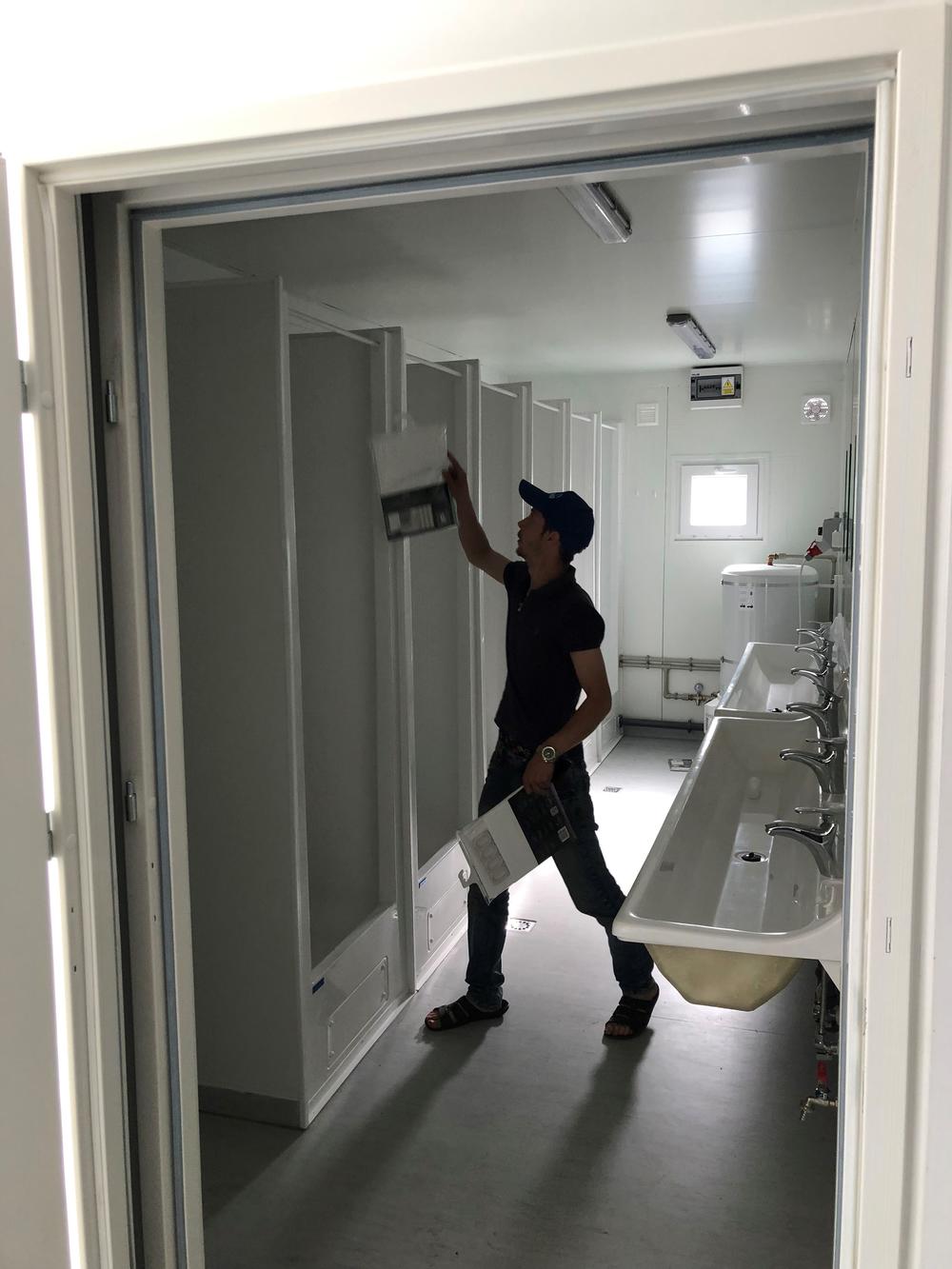 A worker fixes up prefabricated dorms that will soon open to Bucha residents whose homes were destroyed. Poland donated the dorms, which can be constructed in just a few days.