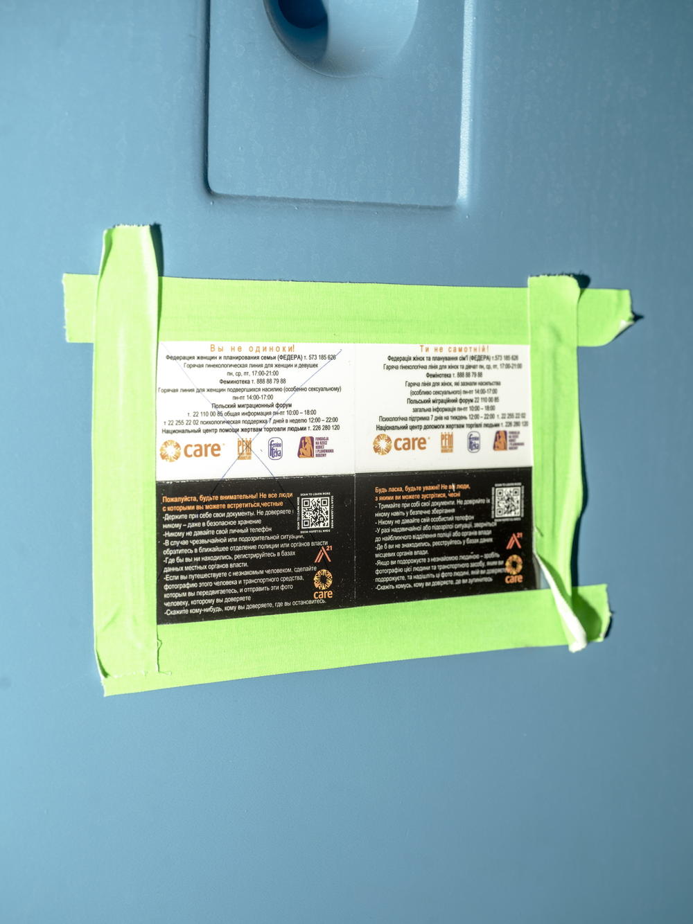 A sign in a portable bathroom at the Medyka border crossing in Poland with phone numbers for a gynecology hotline. There are logos for Polish reproductive rights groups that connect with a network of women's organizations across Europe.