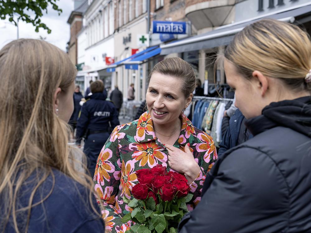 Denmark's Prime Minister Mette Frederiksen, center, speaks to people while on an election campaign, in Holbaek, Denmark, Saturday, May 28, 2022.