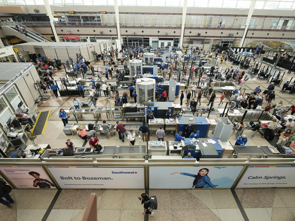 Travelers queue up at a security checkpoint in the main terminal of Denver International Airport on Thursday.