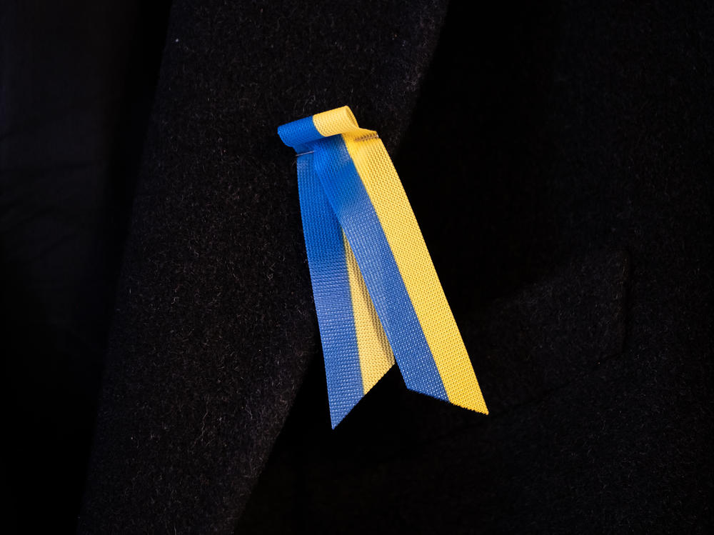 Toomas Hendrik Ilves wears a ribbon pin in support of Ukraine.