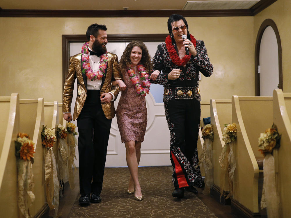 Elvis impersonator Brendan Paul (right) walks down the aisle during a wedding ceremony for Katie Salvatore and Eric Wheeler at the Graceland Wedding Chapel in Las Vegas.