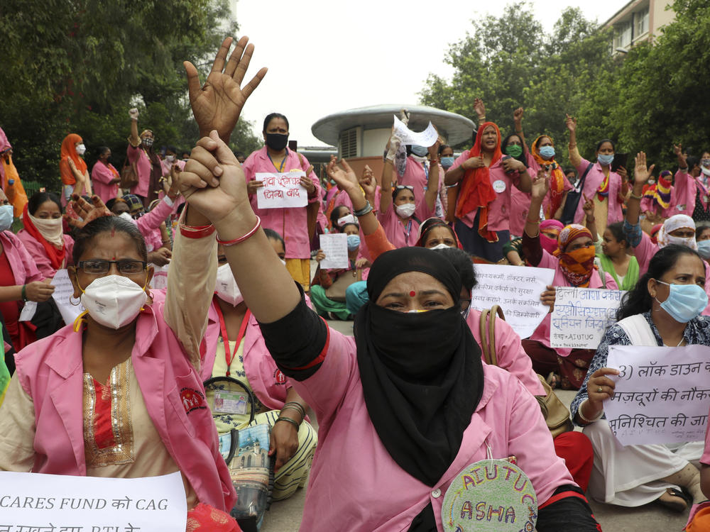 Female community health care workers protest in New Delhi, India, in August 2020. The women are part of a government program called Accredited Social Health Activists — and are demanding higher pay and better working conditions. In May, the program won an award from the World Health Organization.