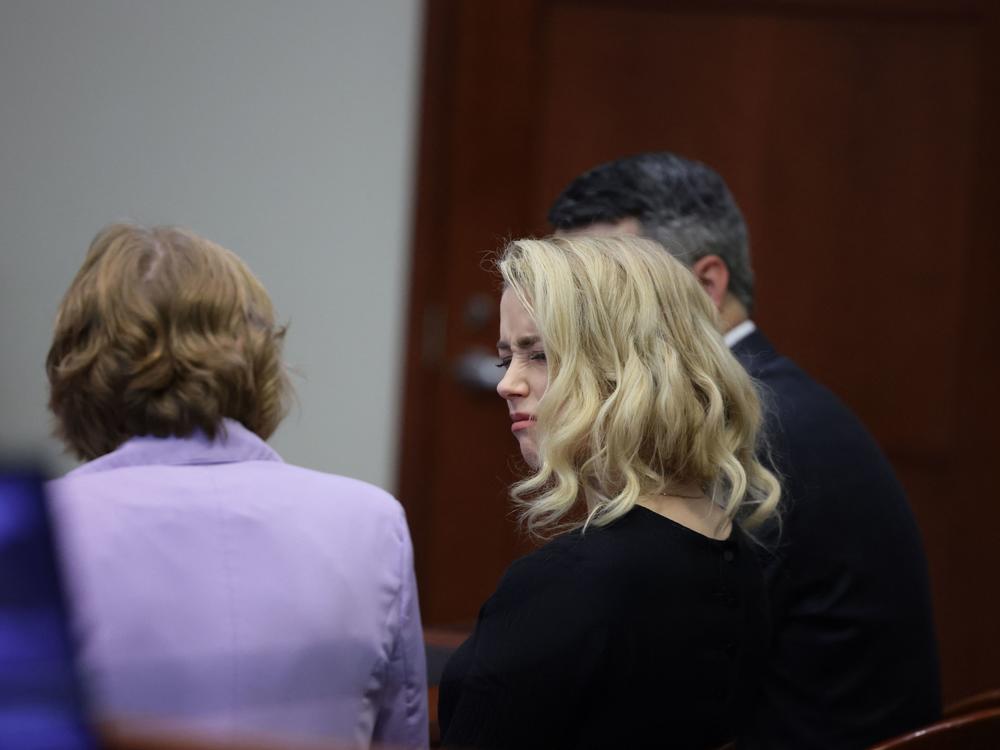 Actor Amber Heard looks at her lawyer before the jury said that they believe she defamed ex-husband Johnny Depp.