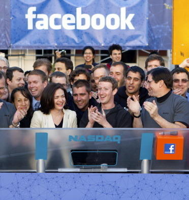 Mark Zuckerberg, chief executive officer of Facebook Inc., center, Sheryl Sandberg, chief operating officer of Facebook, center left, and Robert Greifeld, chief executive officer of Nasdaq OMX Group Inc., center right, applaud after remotely ring the opening bell for trading at the Nasdaq MarketSite from the Facebook campus in Menlo Park, California, U.S., on Friday, May 18, 2012.