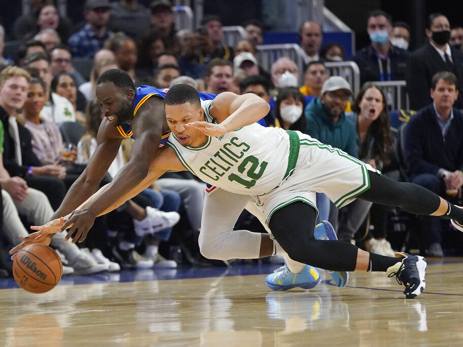 Golden State Warriors forward Draymond Green, left, and Boston Celtics forward Grant Williams reach for the ball March 16 during a regular season game. The two teams will face off in the NBA Finals starting Thursday night.