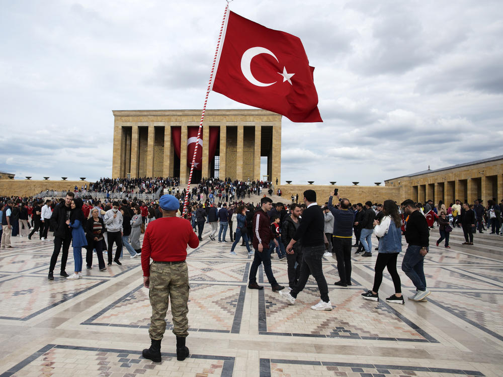 A man stands with a Turkish as flag people visit the mausoleum of Mustafa Kemal Ataturk in Ankara on May 19, the 103rd anniversary of the start of Turkey's War of Independence.