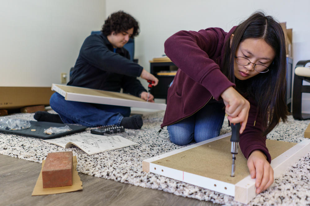 Zoe, right, with the help of her boyfriend, Jackson Daniels, assemble new furniture while moving into the family apartment behind their garage.