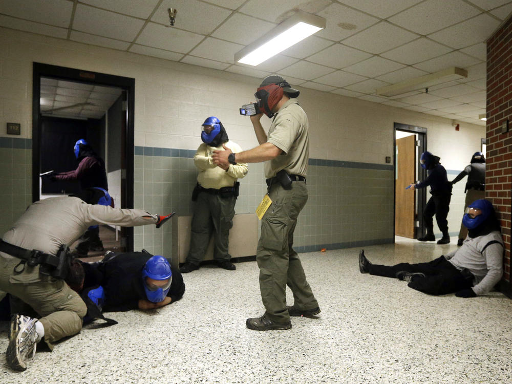 In 2013, FBI instructor Mike Sotka (center) films local police officers as they participate in an active shooter drill in a college classroom building in Salisbury, Md., as part of an FBI program that teaches local law enforcement best practices for responding to mass shootings.