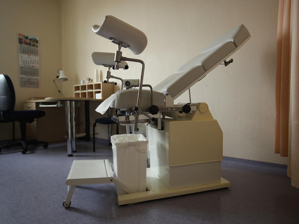 A gynecology chair sits in a doctor's office.