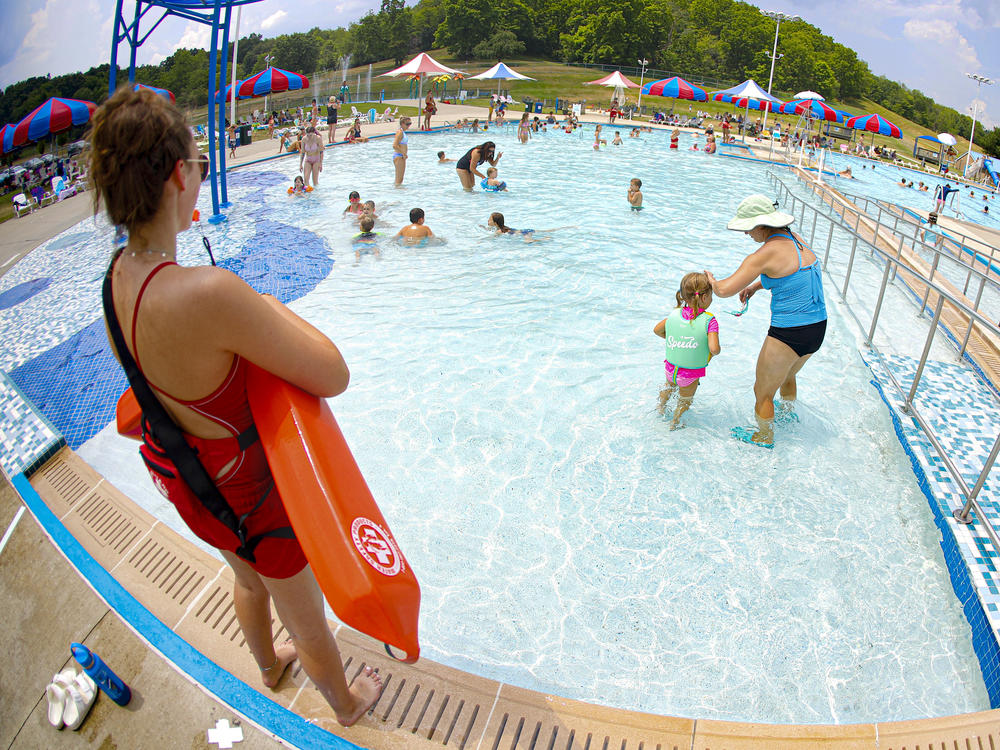 Lifeguard Maggie Storti (left) keeps an eye on visitors to the North Boundary Park swimming pool and waterpark on July 9, 2020, in Cranberry Township, Pa.