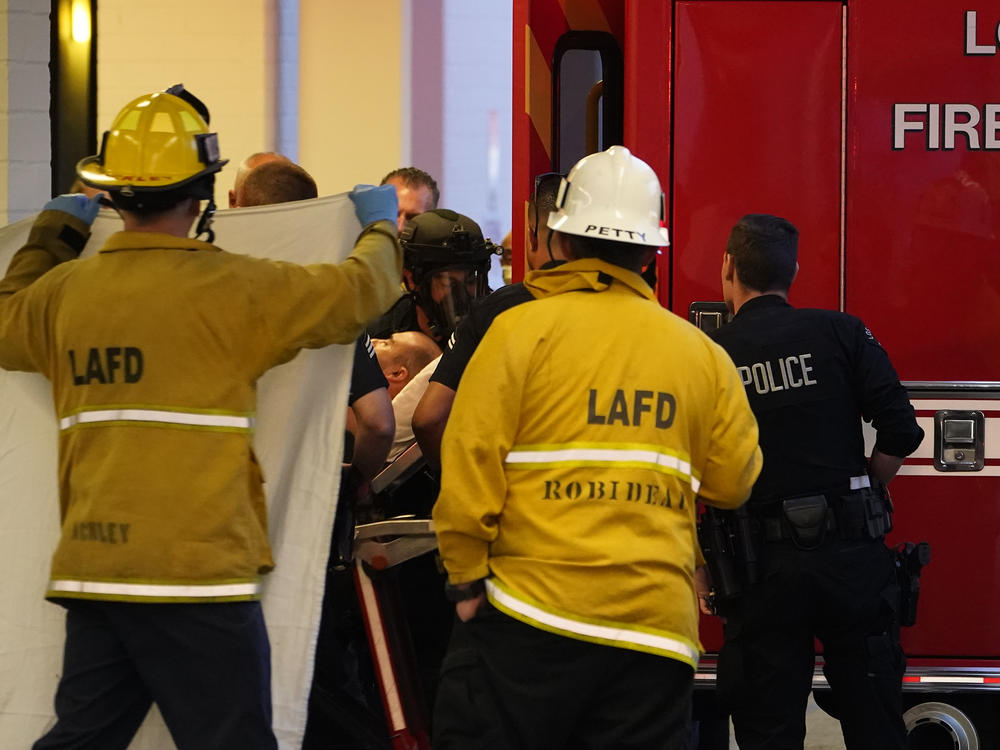 A suspect who stabbed multiple people and barricaded himself inside the Encino Hospital Medical Center is transported into a waiting ambulance after being extracted from the hospital in Encino, Calif., late Friday.