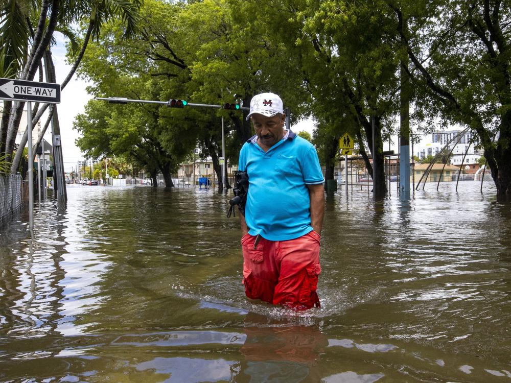 A man crosses the flooded intersection in the Little Havana neighborhood of Miami on Saturday.