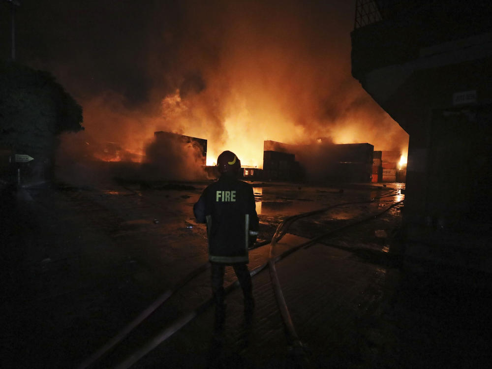A firefighter works to contain a fire that broke out at the BM Inland Container Depot, a Dutch-Bangladesh joint venture, in Chittagong, Bangladesh, early Sunday.