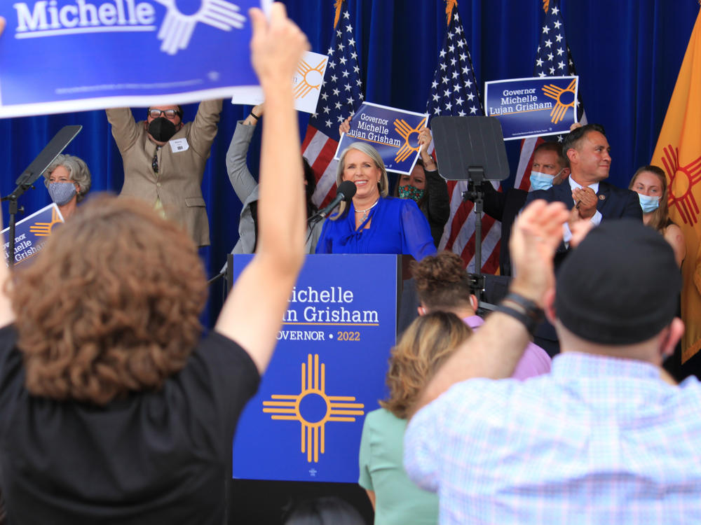 New Mexico's Democratic governor, Michelle Lujan Grisham (center), smiles as supporters cheer during a campaign rally in Albuquerque, N.M., on June 3, 2021. The rally was cut short as protesters chanted loudly beyond the walls of the outdoor venue.
