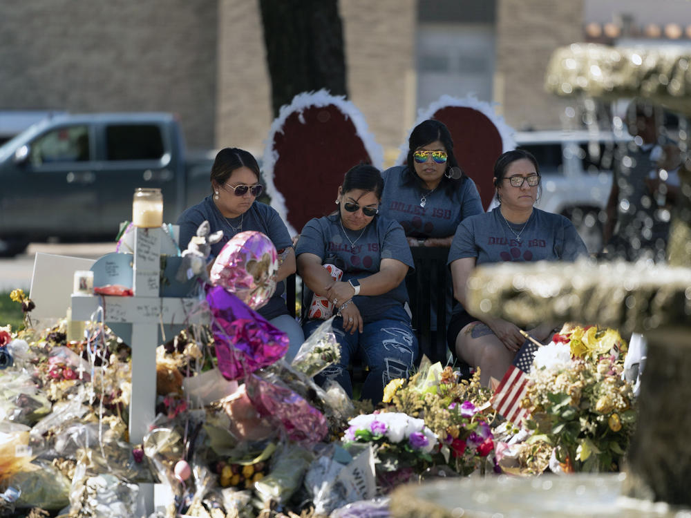 A group of teachers visiting from Dilley, Texas, view a memorial honoring the victims killed in last week's elementary school shooting in Uvalde, Texas, Friday, June 3, 2022.