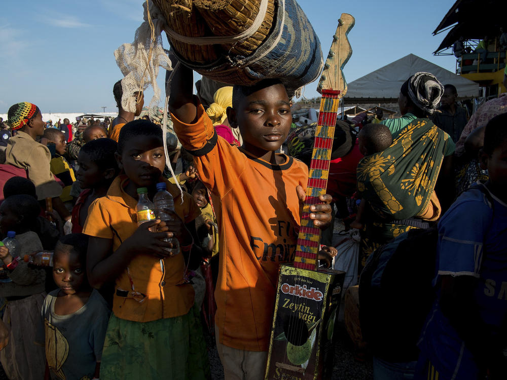 Burundian refugee Richard Samuel, 14, holds his homemade guitar as he waits to be transferred to Nyarugusu refugee camp in Tanzania in 2015.