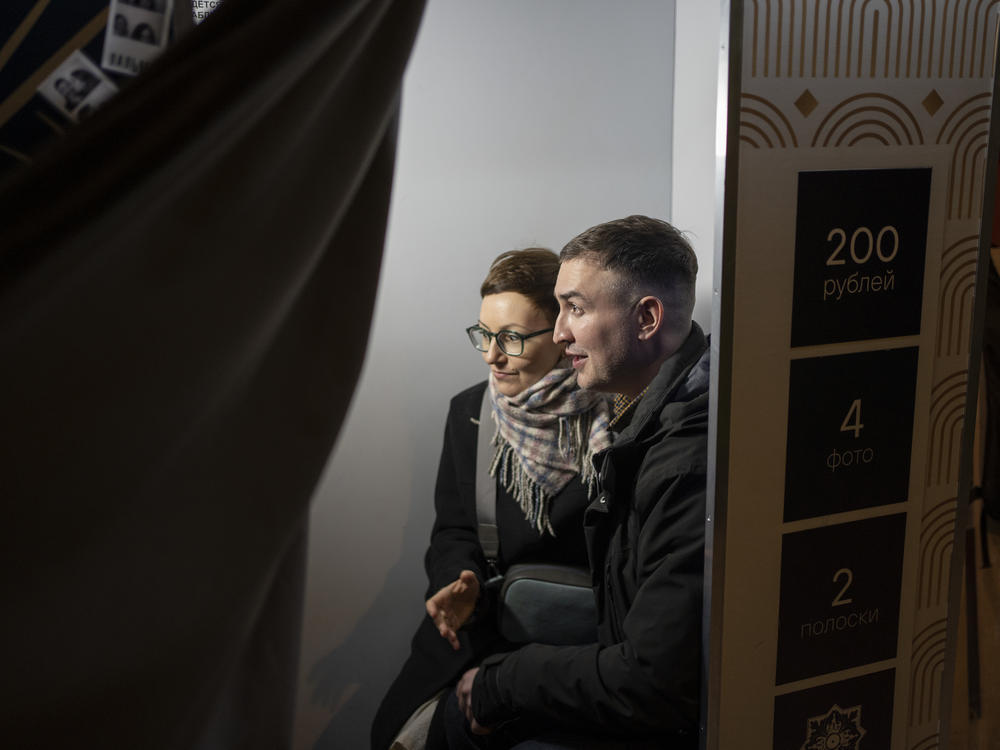 Tatyana and Pyotr got married on a Tuesday among six friends and, afterward, captured the memory at a photo booth.