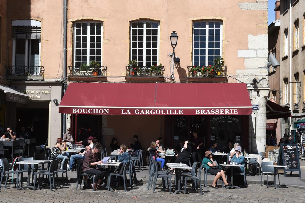 People sit at La Gargouille's cafe terrace on Saint-Jean Square in Lyon, France, in 2016.