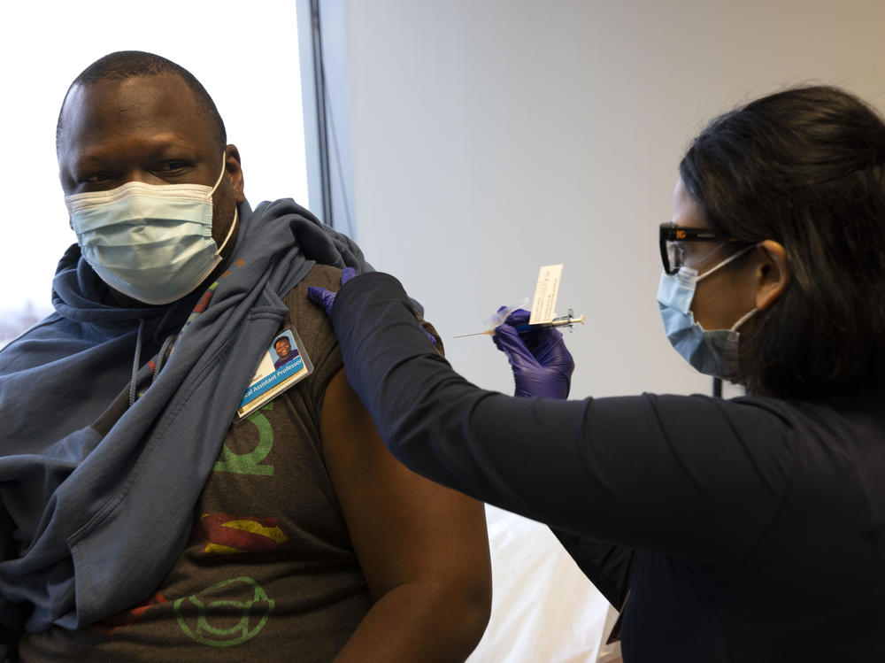 Dr. Stephaun Wallace, who leads the global external relations strategies for the COVID-19 Prevention Network at the Fred Hutchinson Cancer Research Center in Seattle, receives his second injection from Dr. Tia Babu during the Novavax vaccine phase 3 clinical trial in February 2021.