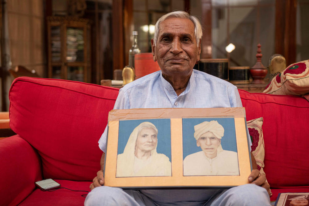 Ishar Das Arora, 83, pages through family photos at his home in New Delhi.