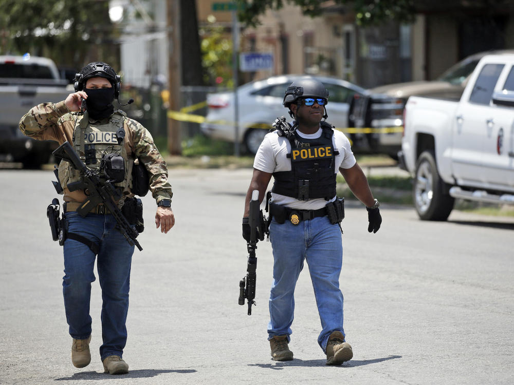 Police walk near Robb Elementary School following a shooting.