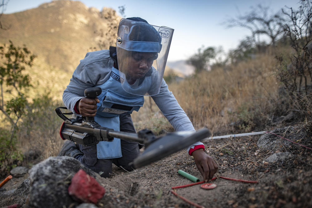Amelia Ngola, 30, marks out the location of a suspected landmine before beginning to excavate the area in a minefield in Benguela province, Angola. The first step is to dig down and find out if it was a mine that set off her mine detector or something else — say, a rusty soda can or an old bullet casing. If it is indeed a mine, then it will be marked with stakes and signs until it's destroyed.