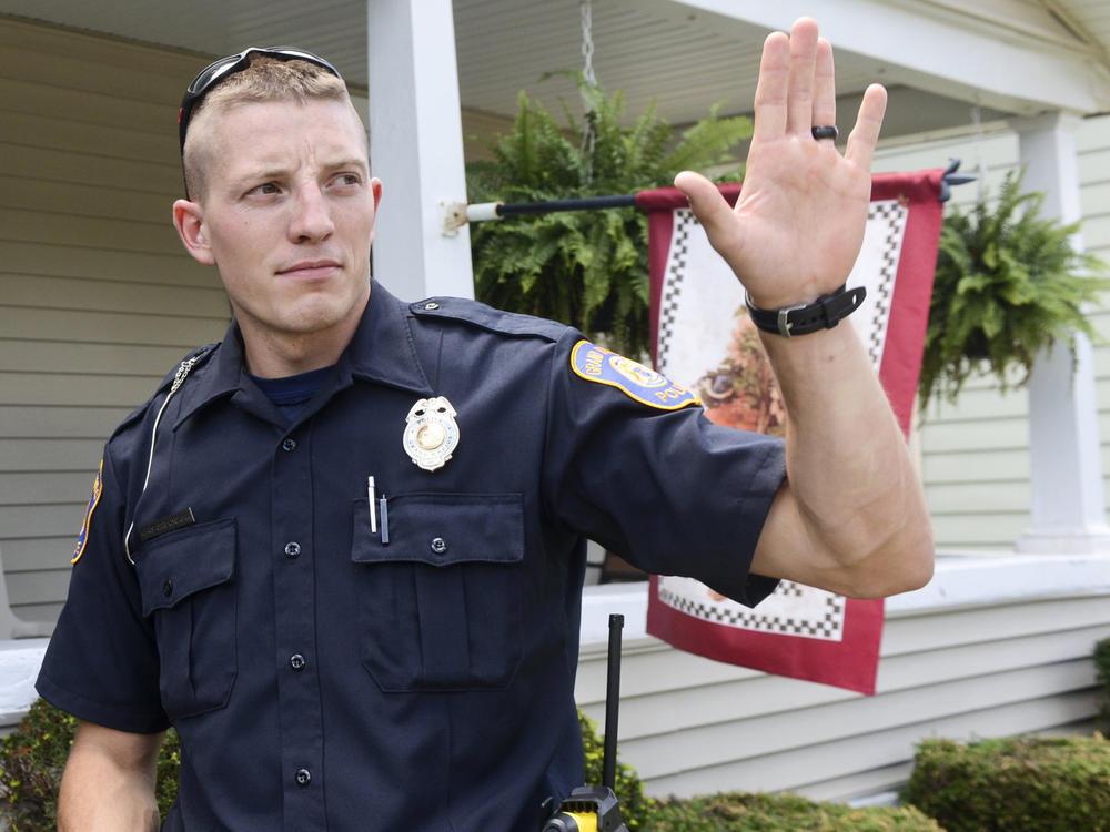 Grand Rapids police officer Christopher Schurr stops to talk with a resident in 2015 in Grand Rapids, Mich.