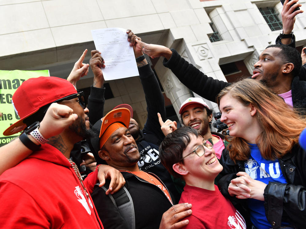 Amazon Labor Union president Chris Smalls (left) celebrates with Amazon workers following the April 1, 2022, tally of votes in the union election at an Amazon warehouse on Staten Island in New York.