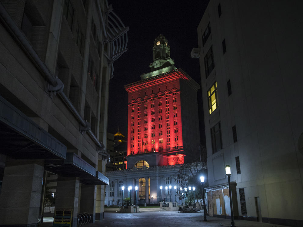 Oakland City Hall is bathed in red light in a memorial to the people who have died from COVID-19 throughout the country in Oakland, Calif. in January 2021.