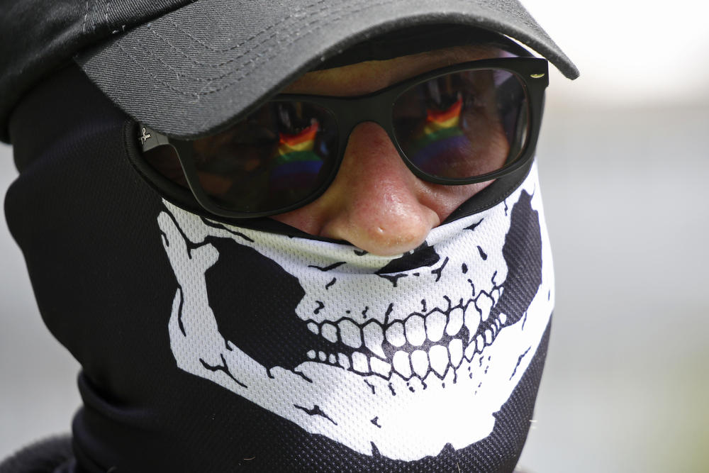 The Pride flag is reflected in the glasses of a white nationalist that came to protest.